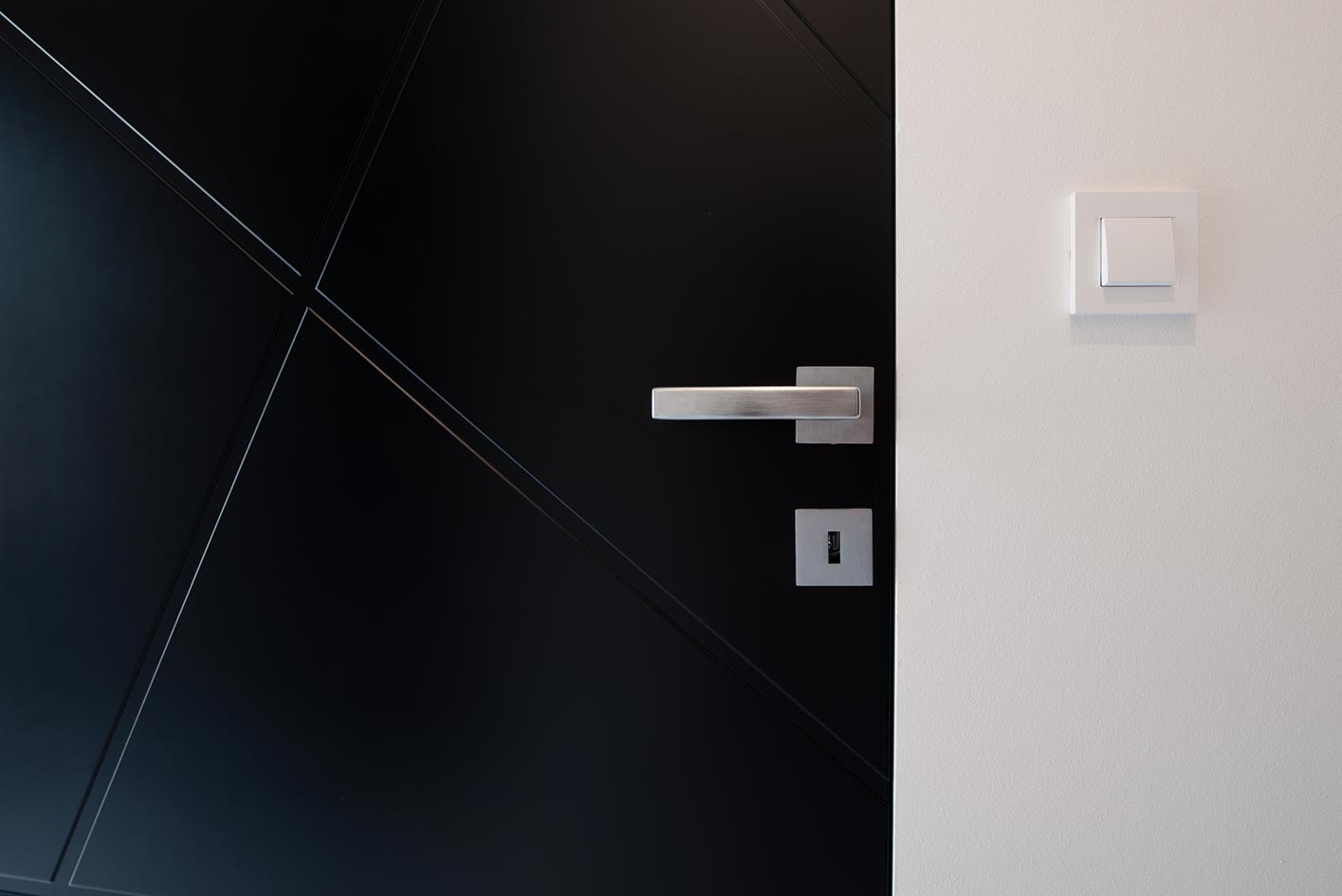 Schwarze Tür mit Edelstahldetail Detailaufnahme einer schwarzen Tür mit Edelstahlgriff