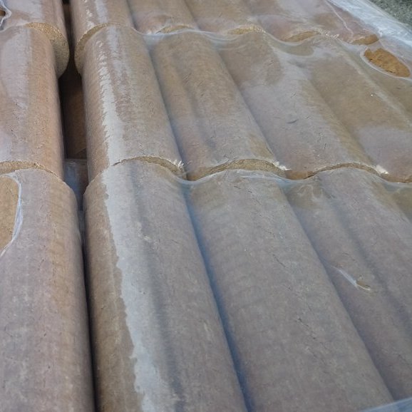 Nahaufnahme von runden Holzbriketts in Folienverpackung – Oberfläche und Form klar erkennbar